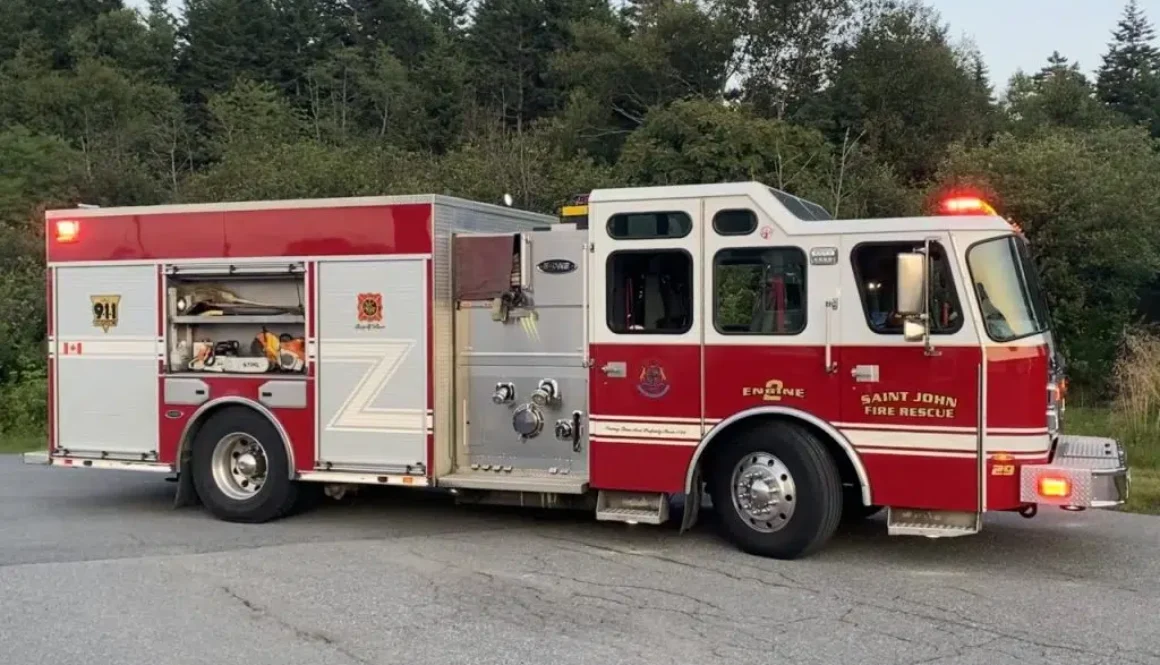 A Saint John Fire Department truck with its lights flashing is parked at the scene of a call.