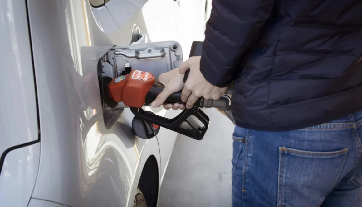 a man pumping gas into his car at a gas station