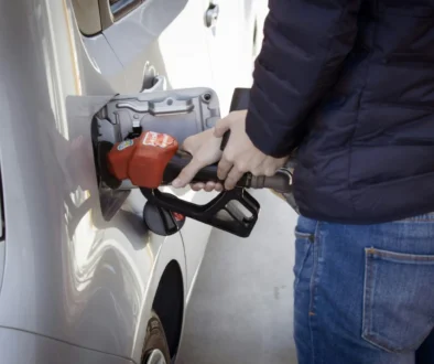 a man pumping gas into his car at a gas station