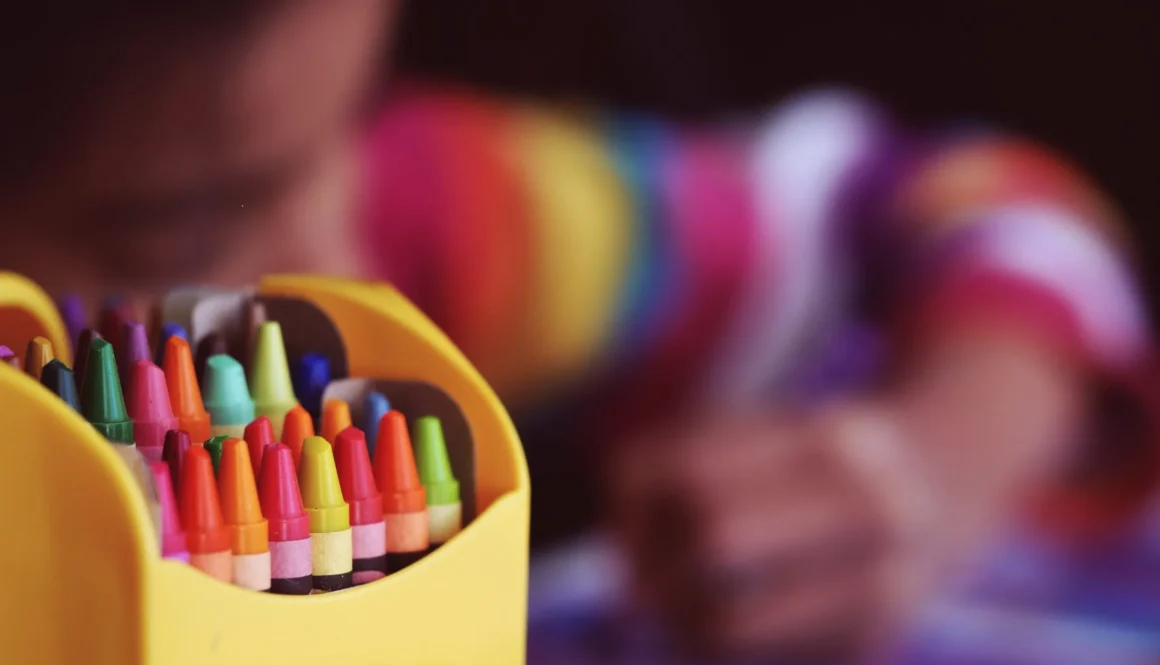 selective focal photo of crayons in yellow box