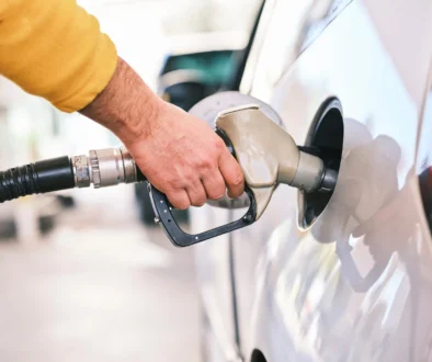 a man pumping gas into his car at a gas station