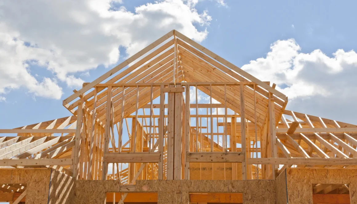 New residential construction home framing against a blue sky