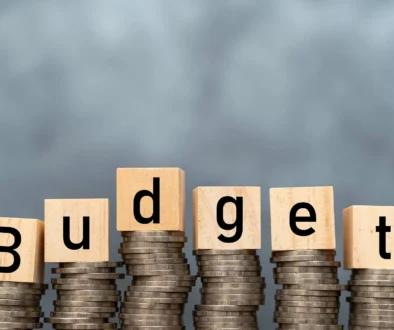 Money annual budget concept. stacked coins and wooden cubes with word Budget on coins background. Free space for advertising materials