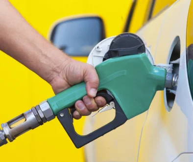 Pumping gas at gas pump. Closeup of man pumping gasoline fuel in