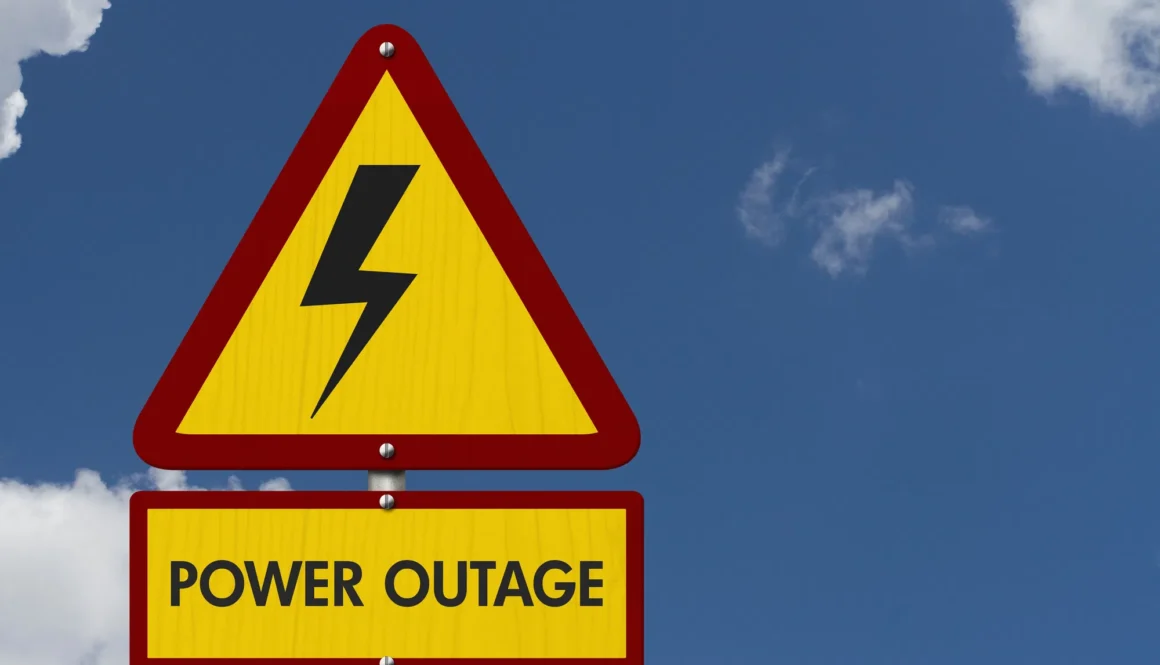 Power Outage message on yellow warning road sign with sky