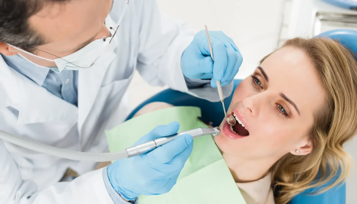 Female patient at dental procedure using dental drill in modern dental clinic