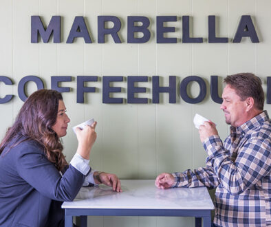 MarBella-people-at-table-with-sign-behind-them