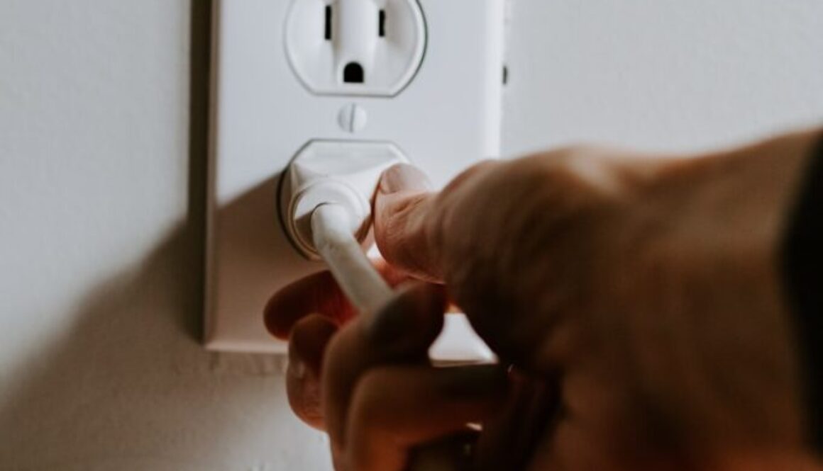 person holding white electric plug