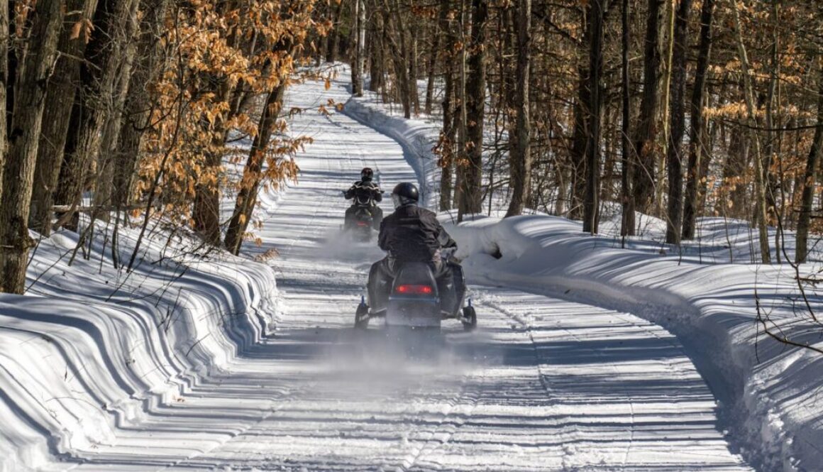 A group of people riding down a snow covered road