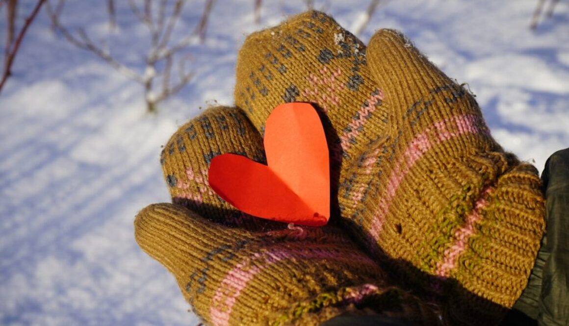 a glove with a heart on it in the snow