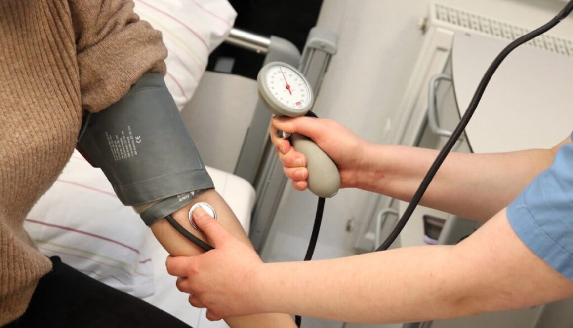 A person with a blood pressure device in their hand