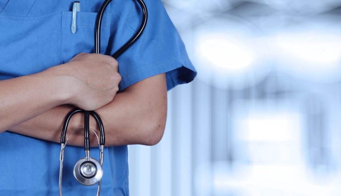 a person in scrubs with a stethoscope on their arm