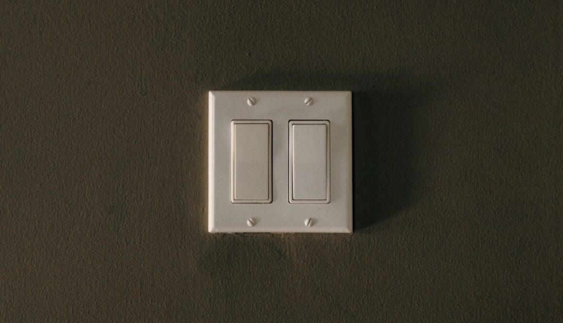 a white light switch sitting on top of a wall