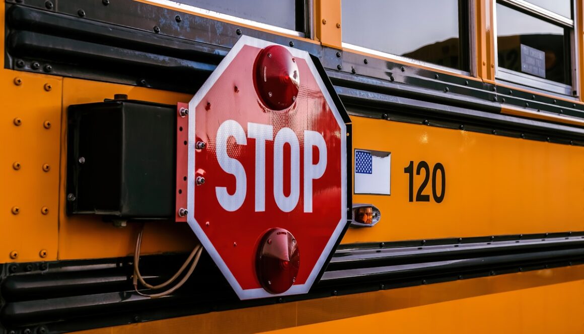 a stop sign attached to the side of a school bus