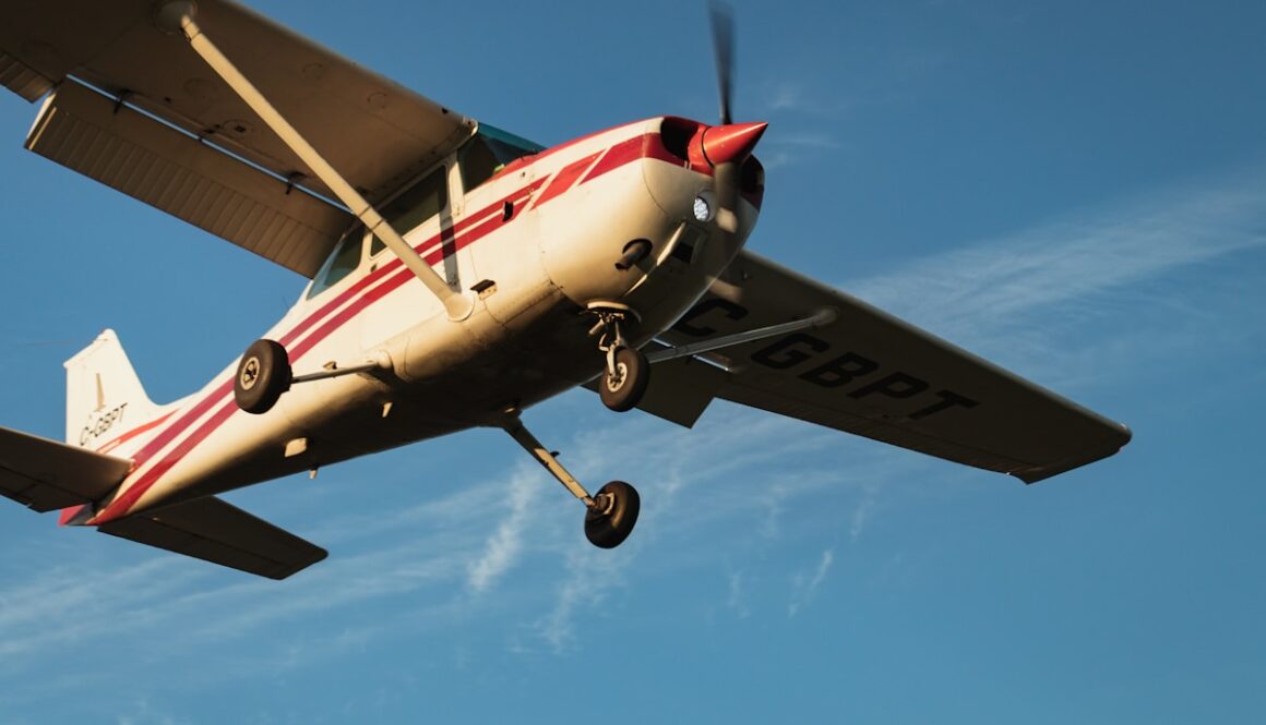 white and red airplane under blue sky during daytime