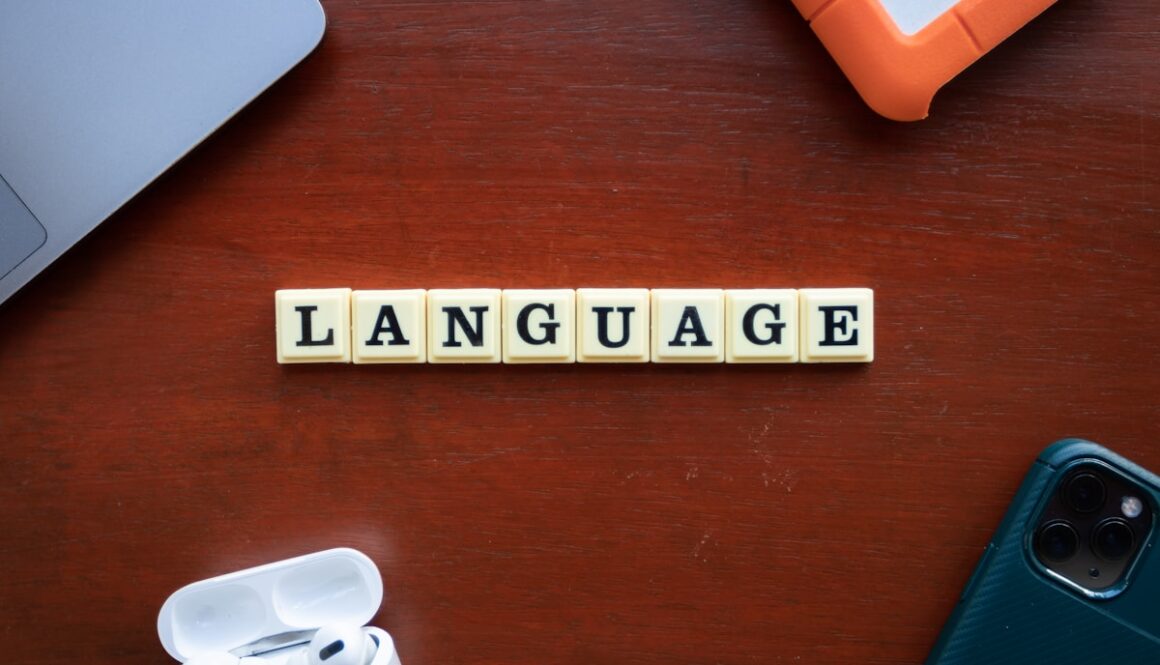 the word language spelled with scrabble tiles on a table