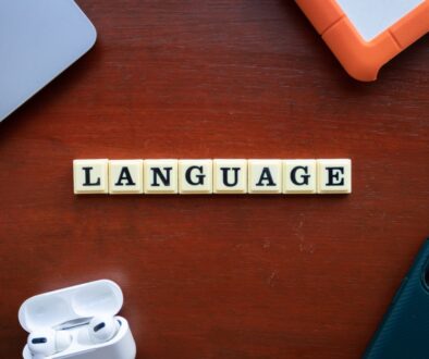 the word language spelled with scrabble tiles on a table