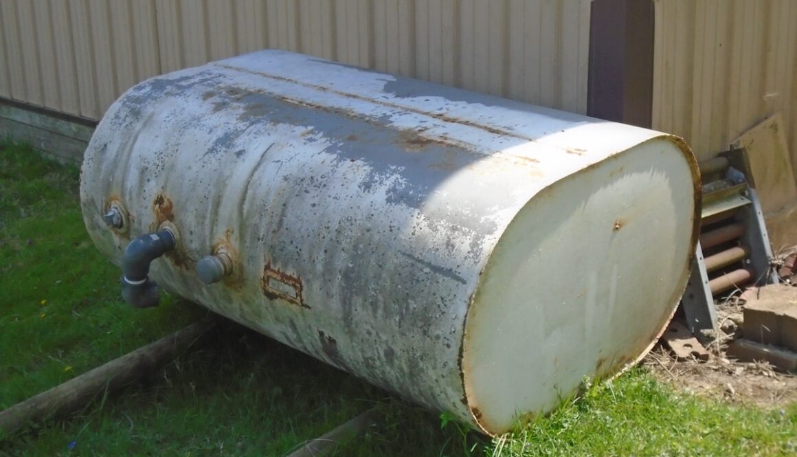 a large metal barrel sitting on top of a lush green field