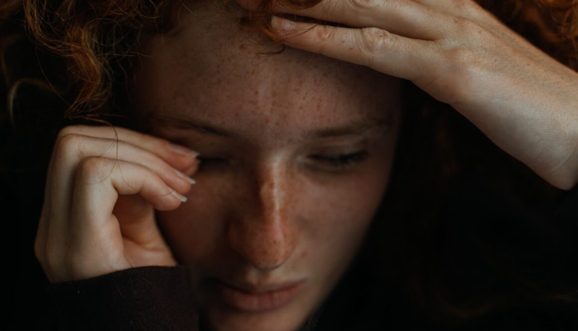 a close up of a person holding their head