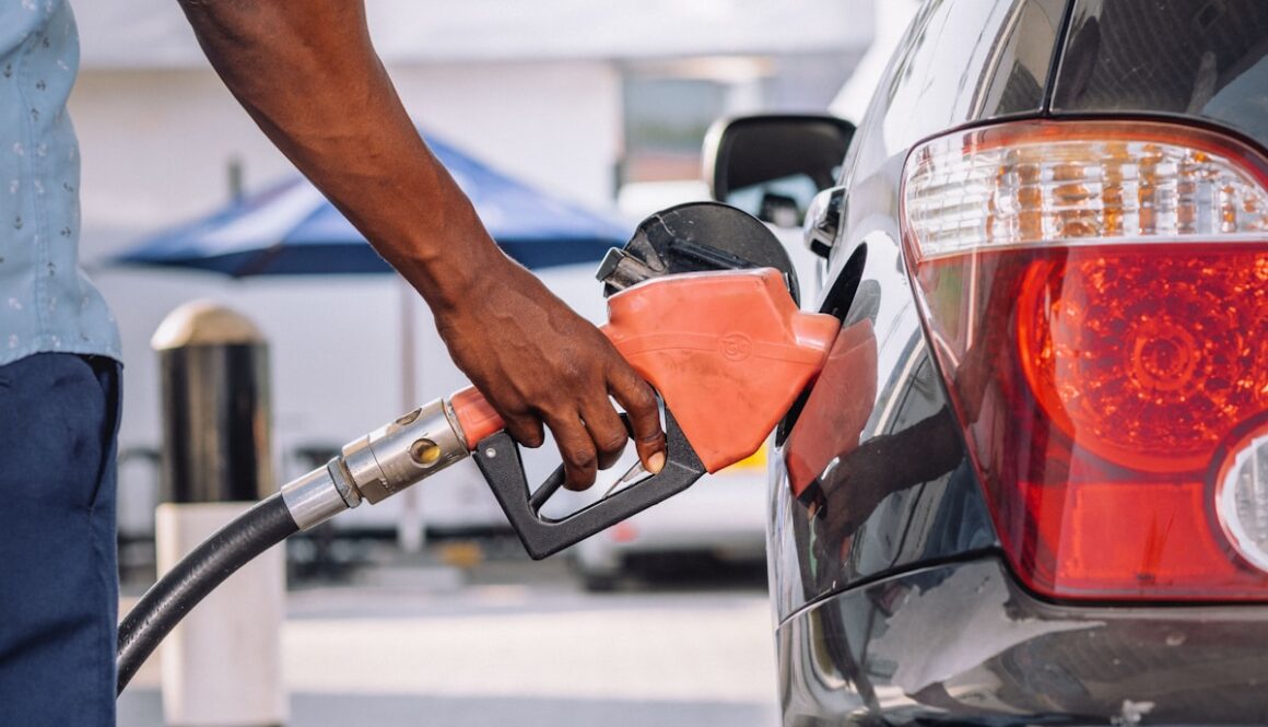 a man pumping gas into his car at a gas station