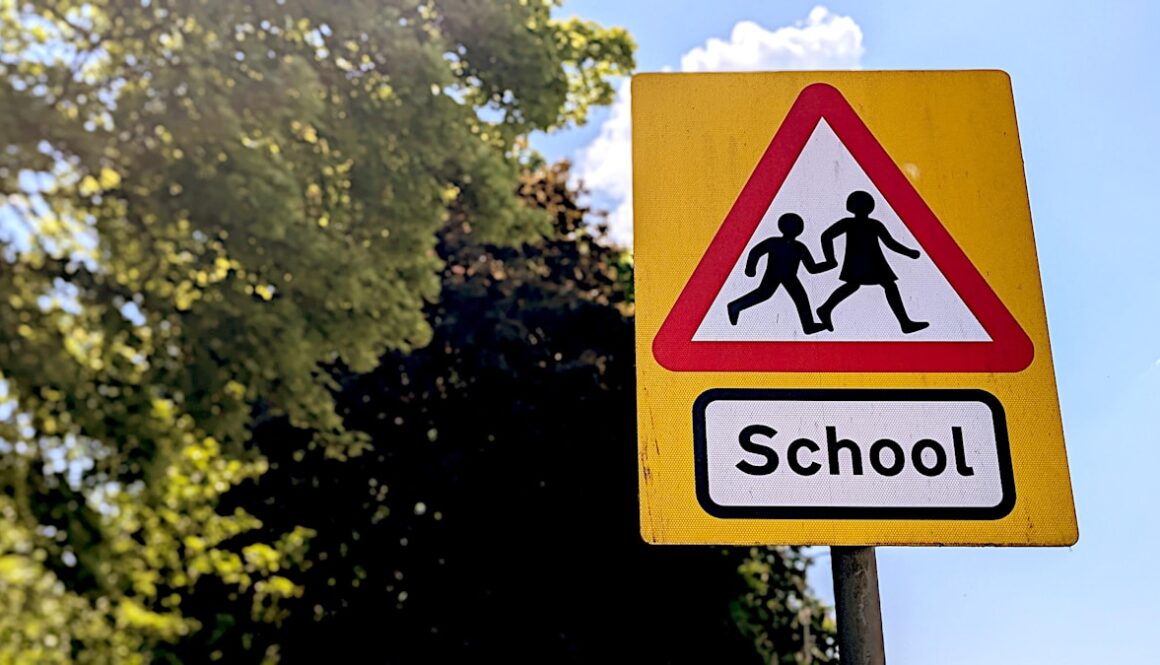 School crossing warning sign with children silhouettes
