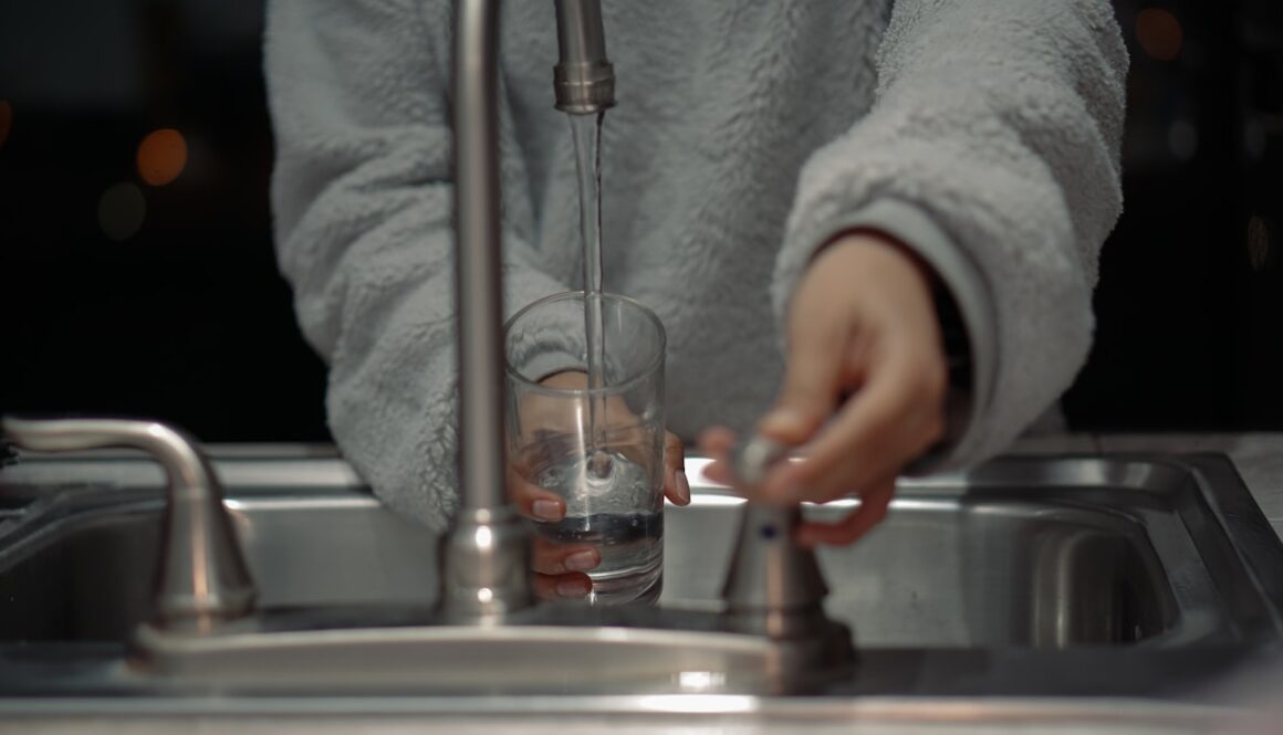 person holding clear glass container