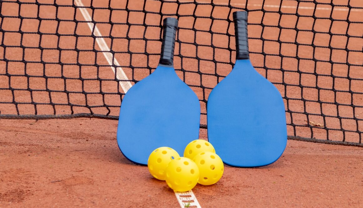 two paddles and three balls on a tennis court