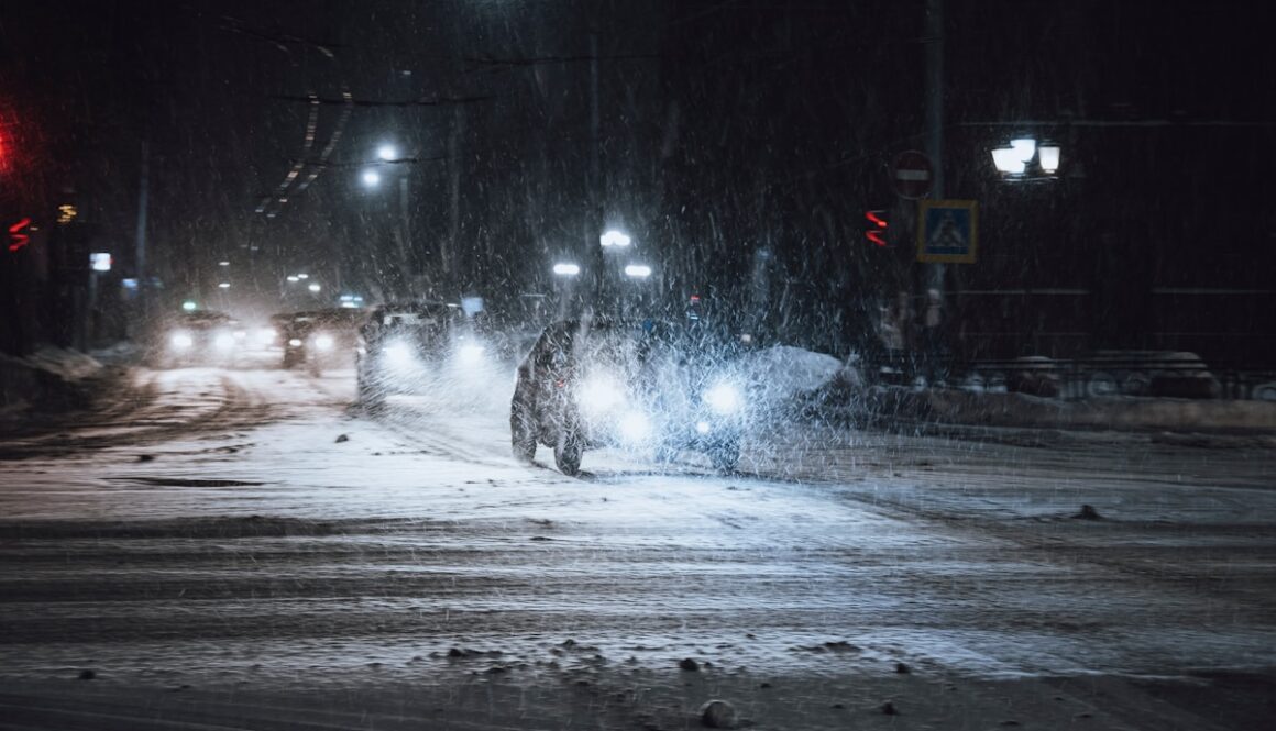 a person walking across a snow covered street at night