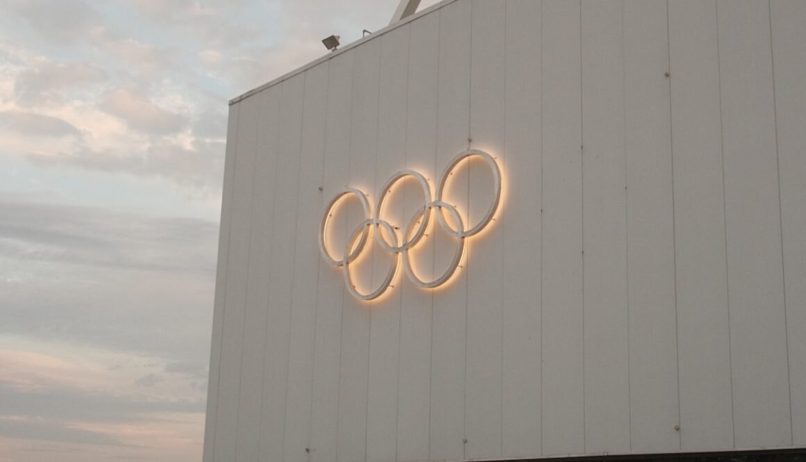 White building with illuminated olympic rings symbol