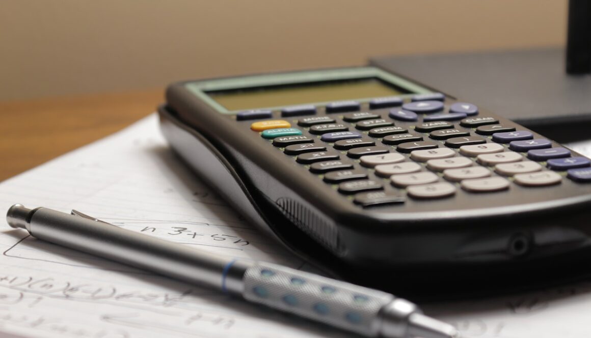 a calculator and a pen sitting on top of a piece of paper