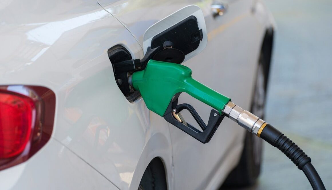 a white car with a green gas pump