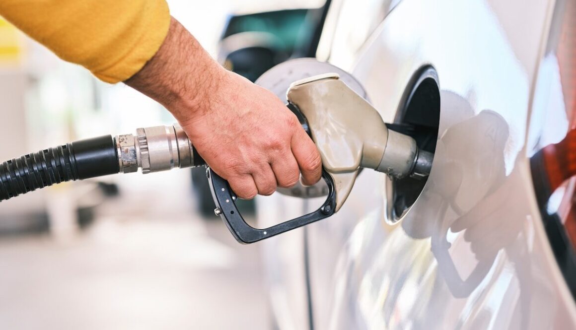 a man pumping gas into his car at a gas station