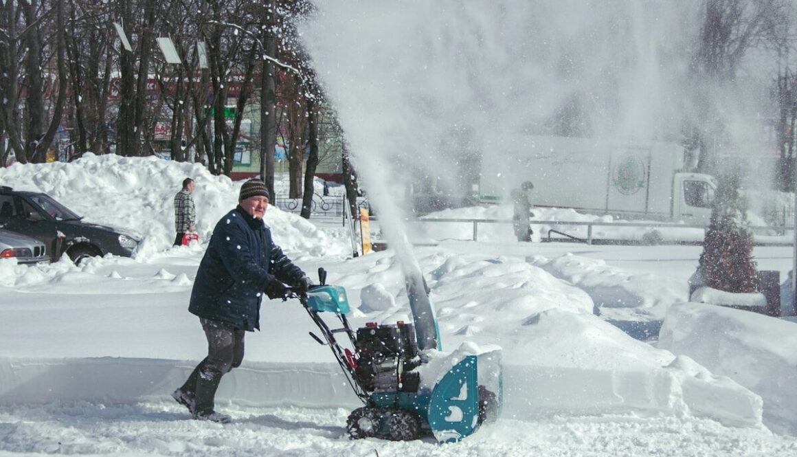 Man operating snow blower during snowfall