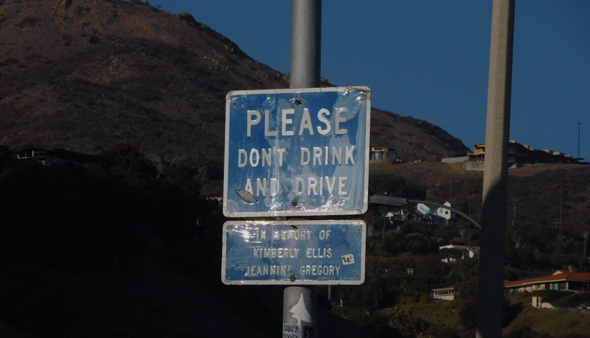 a blue and white street sign sitting on the side of a road