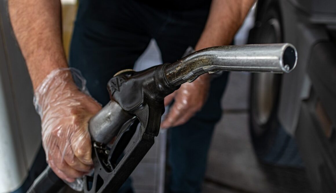 a man pumping gas into a car at a gas station