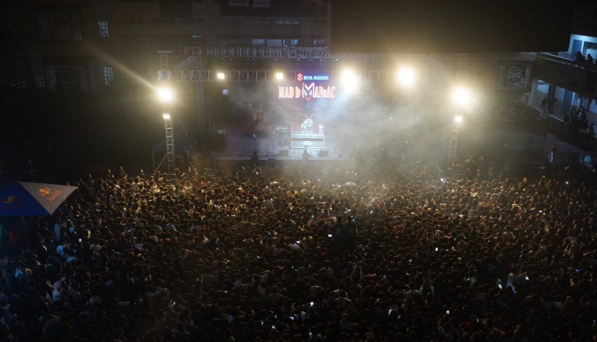 Crowd gathered at a night concert with stage lights