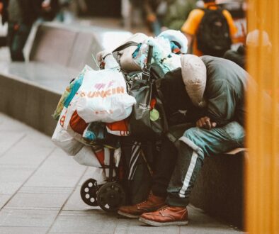 a man sitting on a bench with a bunch of bags