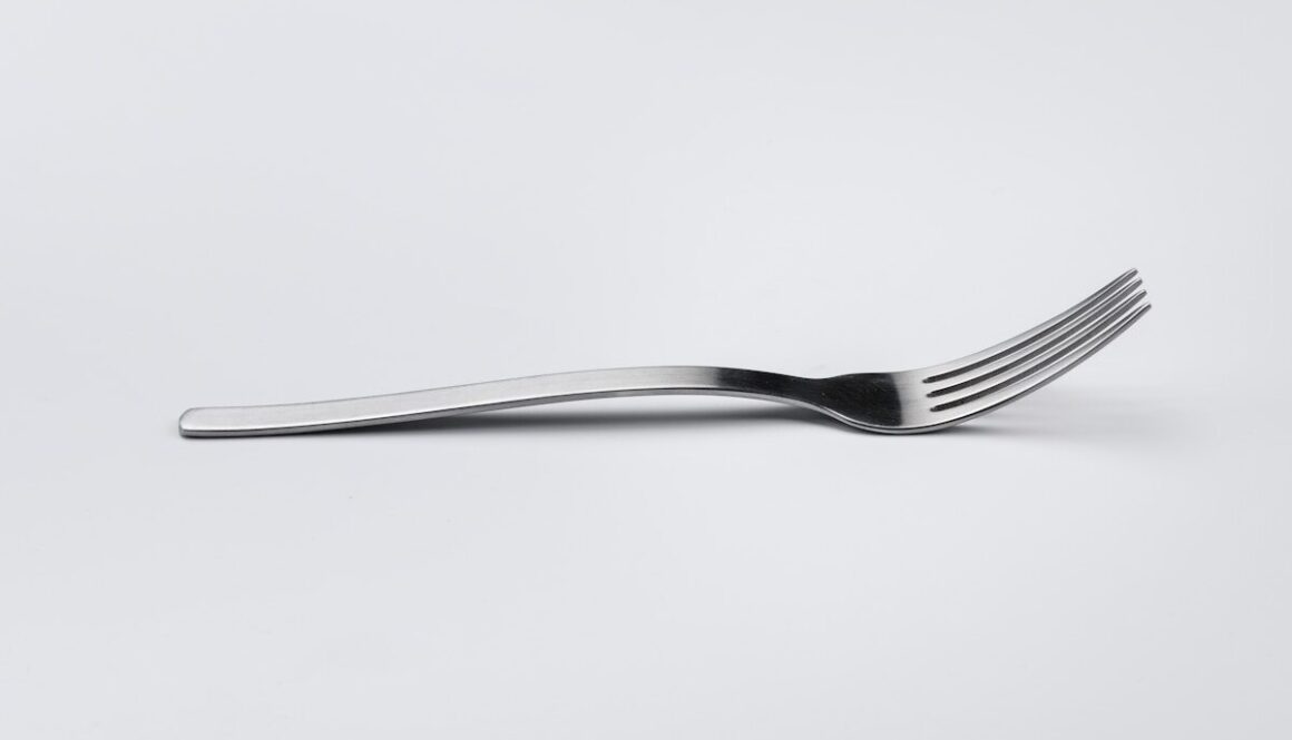 stainless steel fork on white surface