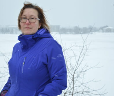 Woman in a blue winter jacket poses for a picture