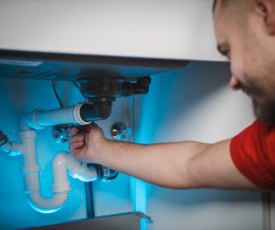 a man working on a pipe in a wall