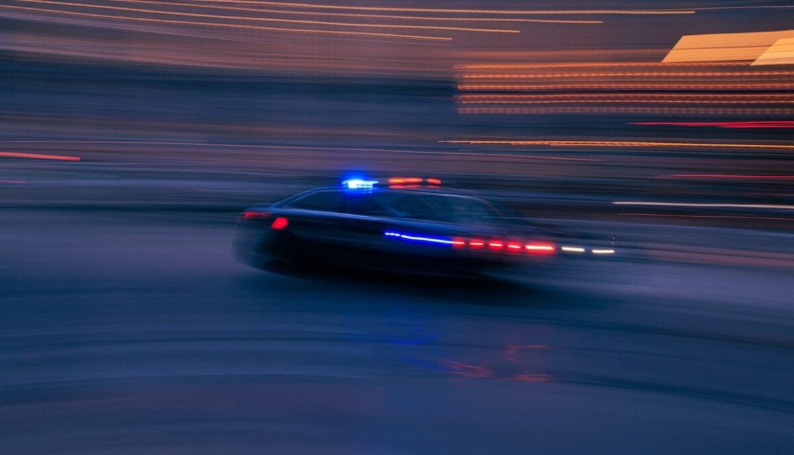 a police car driving down a street at night