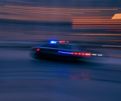 a police car driving down a street at night