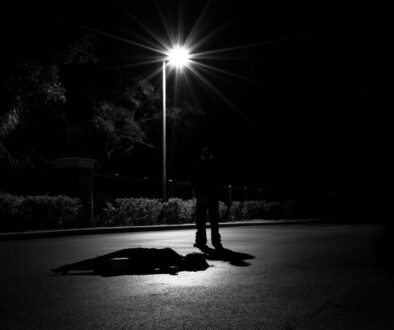 a person laying on the ground under a street light