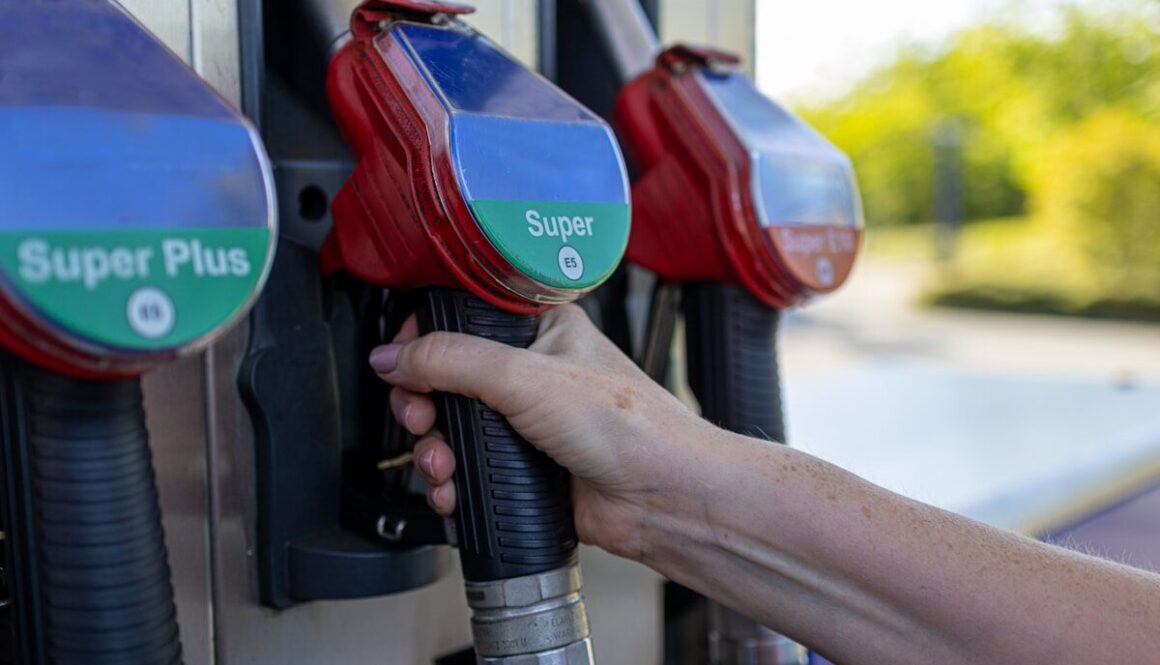 a person's hand is holding a gas pump