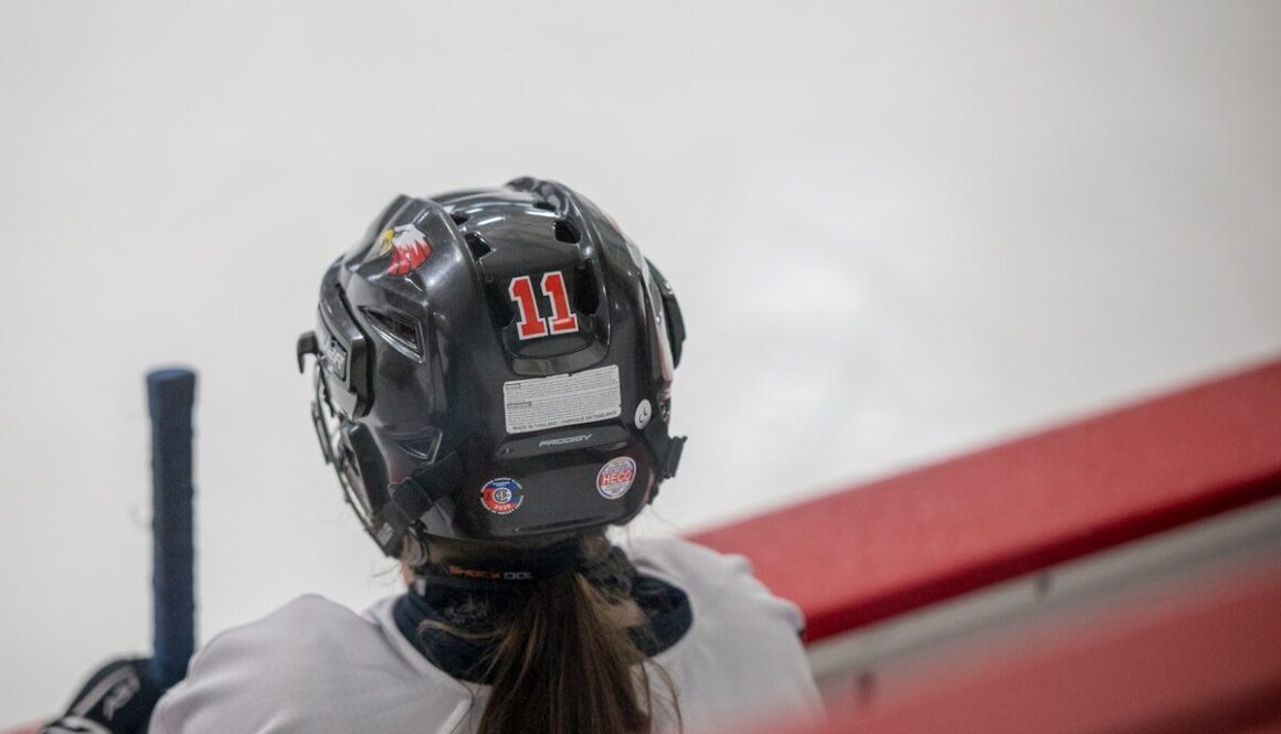 a female baseball player wearing a helmet and holding a bat