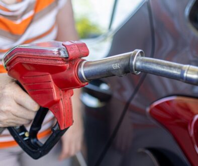 a woman filling a car with gas at a gas station