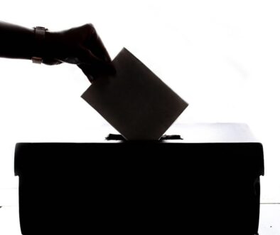 a person is casting a vote into a box