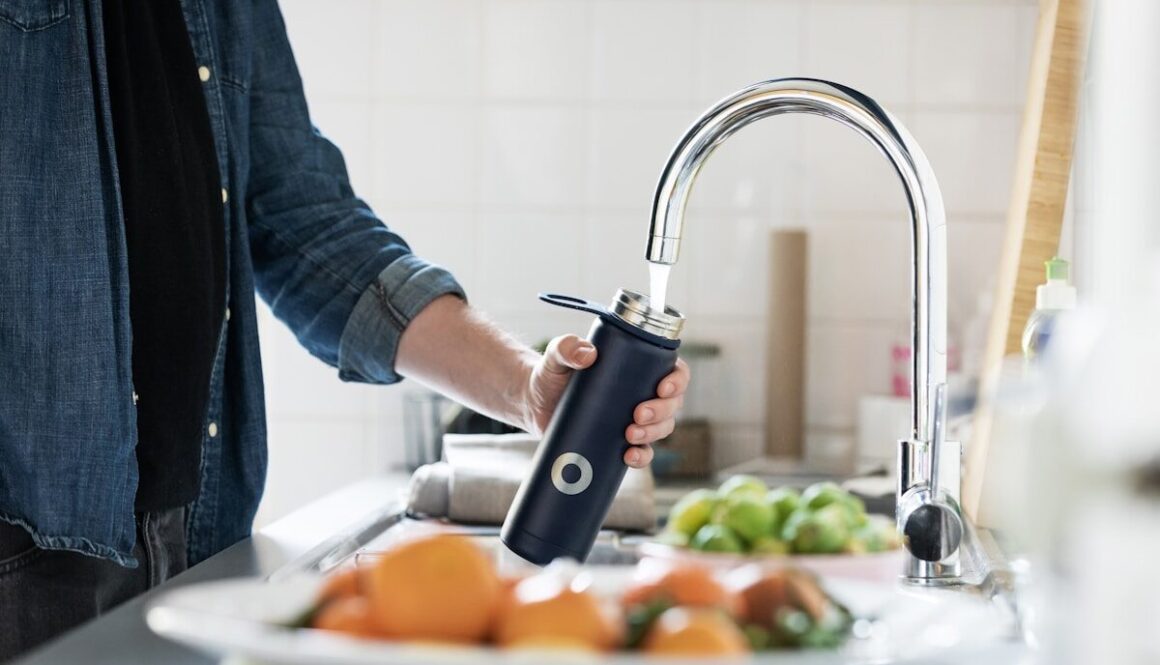person holding stainless steel faucet
