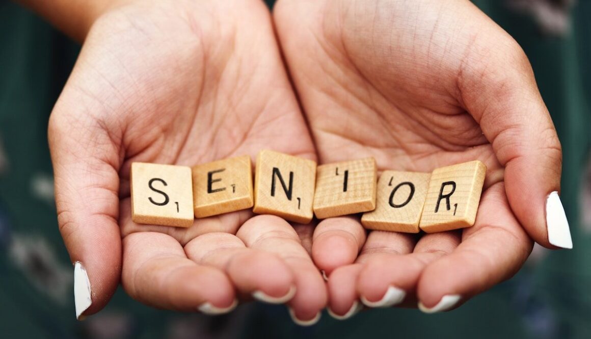 Senior dice on person's palm