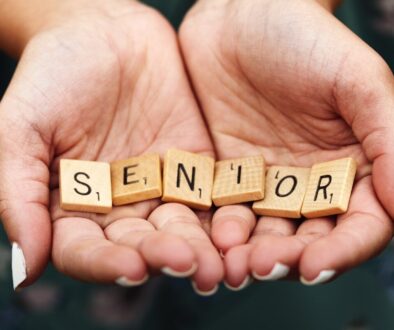 Senior dice on person's palm